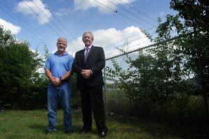 Johnny Miller, vice president and general manager of steel recycler Gerdau, left, and Art Cate, executive director of Knoxville Community Development Corp., stand on land in Lonsdale Homes on which a new park with playground in memory of Zaevion Dobson is planned. KCDC and Gerdau donated the land and each are donating $10,000 toward the park's $60,000 cost, hoping the community will donate the balance. (CAITIE MCMEKIN / NEWS SENTINEL)