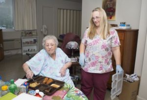 Housekeeper Paula Spence, right, delivers dinner to Northgate Terrace resident Frieda Dixon last week. The Manor at Northgate Terrace program serves low-income seniors who can live independently with some help, but its coordinator says its costs are outpacing its budget. (PAUL EFIRD/NEWS SENTINEL)