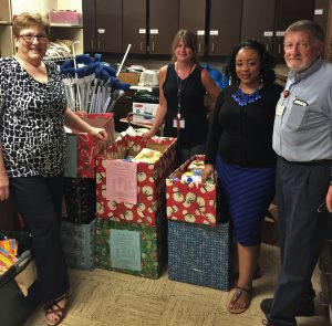 KCDC’s Community Involvement Committee members deliver 15 “Christmas in July” boxes for the Knoxville-Knox County Community Action Committee Pillow Project on Aug. 1. The boxes, filled with personal hygiene and household items, are delivered as housewarming gifts to individuals and families who transition out of homelessness and into permanent housing. Pictured from left: Knoxville’s Community Development Corporation employees Diana Willett, Jennifer Bell, Shana Love and Robert Justice.